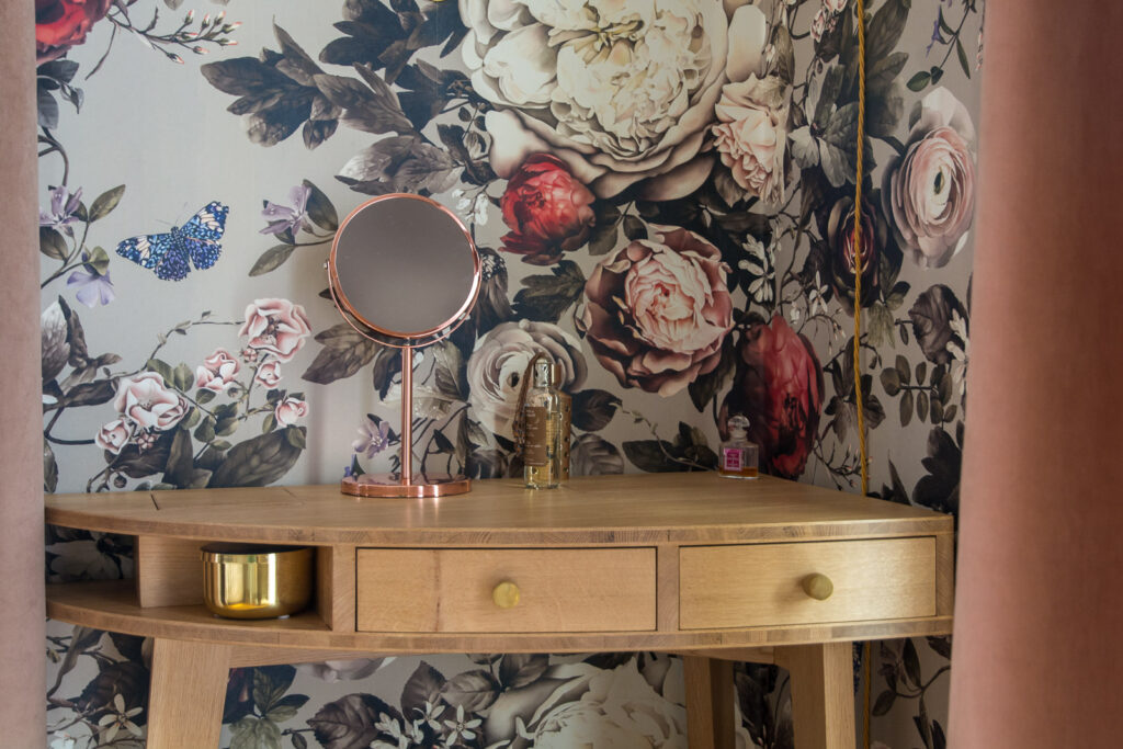 Coiffeuse en chêne de style Art déco dans un intérieur agrémenté d'une tapisserie fleurie