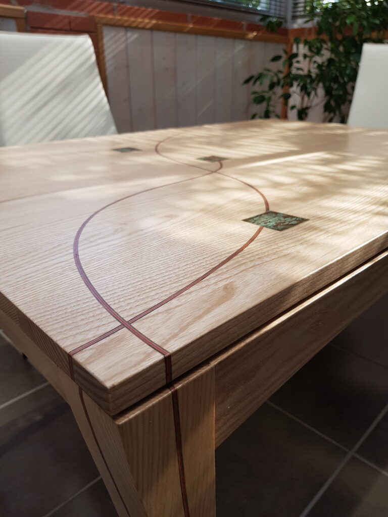 Table en frêne avec rallonge en noyer, incrustations de bois, laiton gravé.